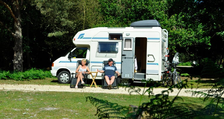 Two people sat at Ocknell campsite in the New Forest.