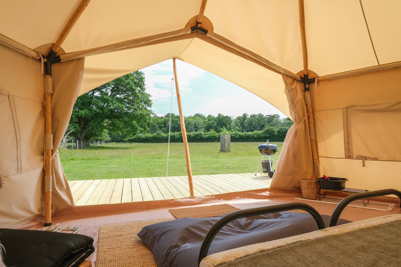View from inside a bell tent looking out over open meadow at Long Meadow