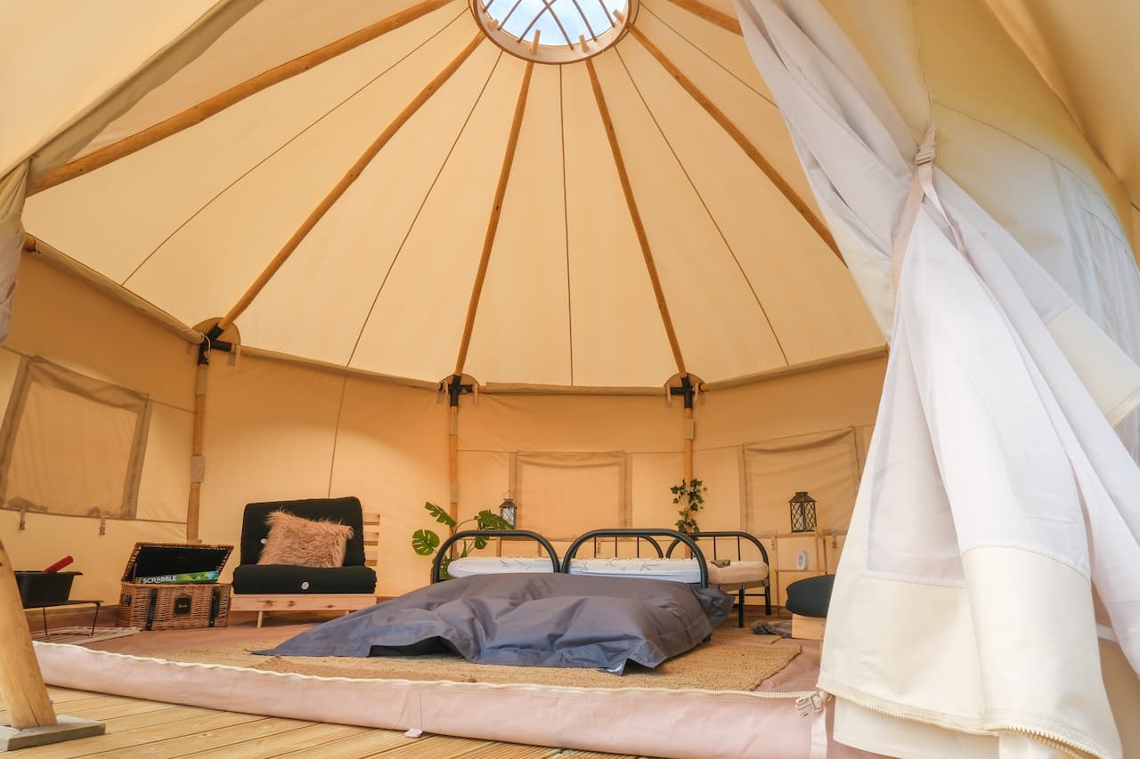 Interior of a bell tent at Long Meadow with double beds and soft furnishings