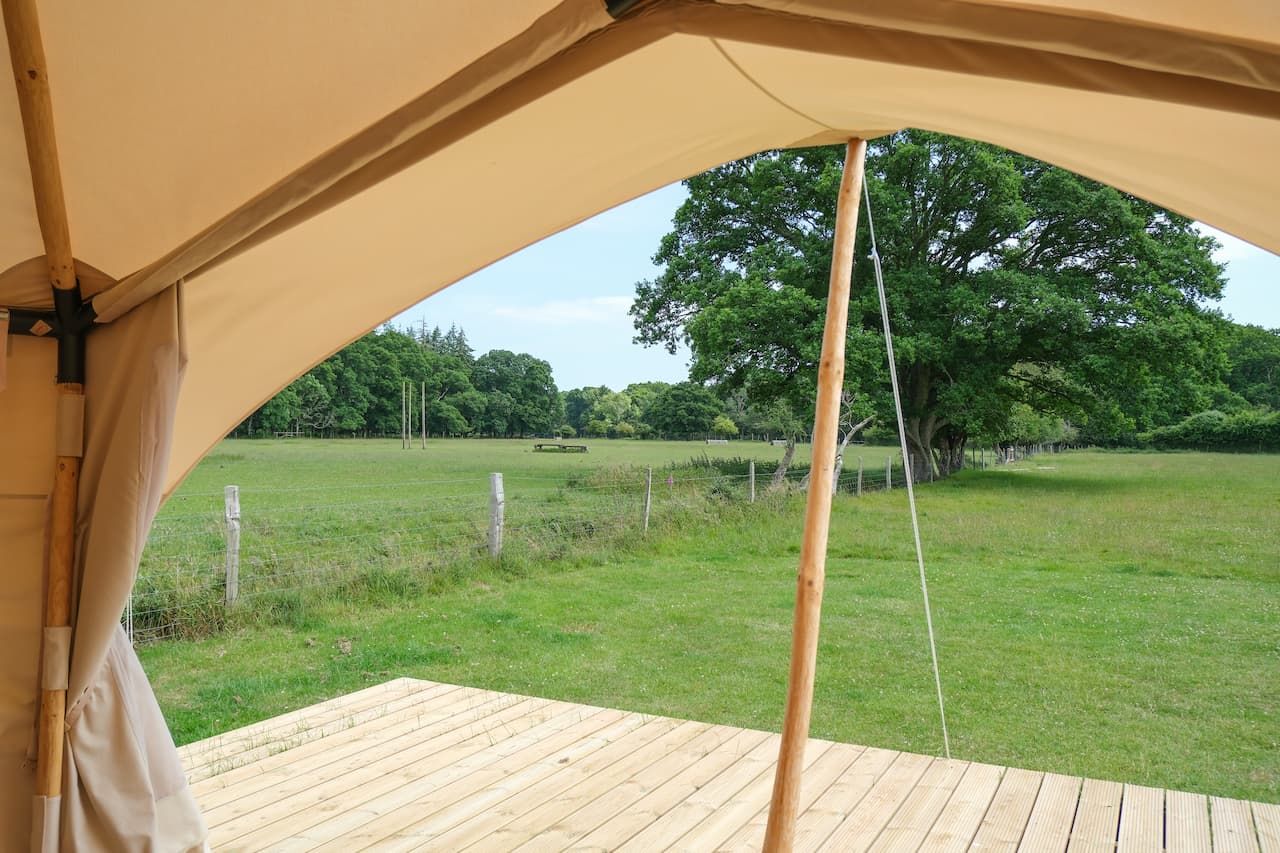 View from a glamping Burt tent at Long Meadow looking out over open fields