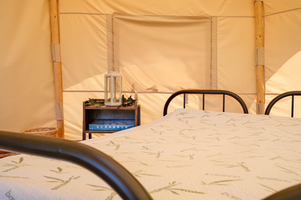 Interior of a Burt glamping tent with twin beds and soft furnishings in the New Forest, Ashurst Campsite